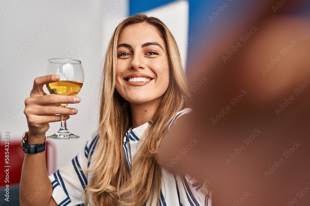 Young blonde woman make selfie by the smartphone drinking champagne at home Young blonde woman make selfie by the smartphone drinking champagne at home