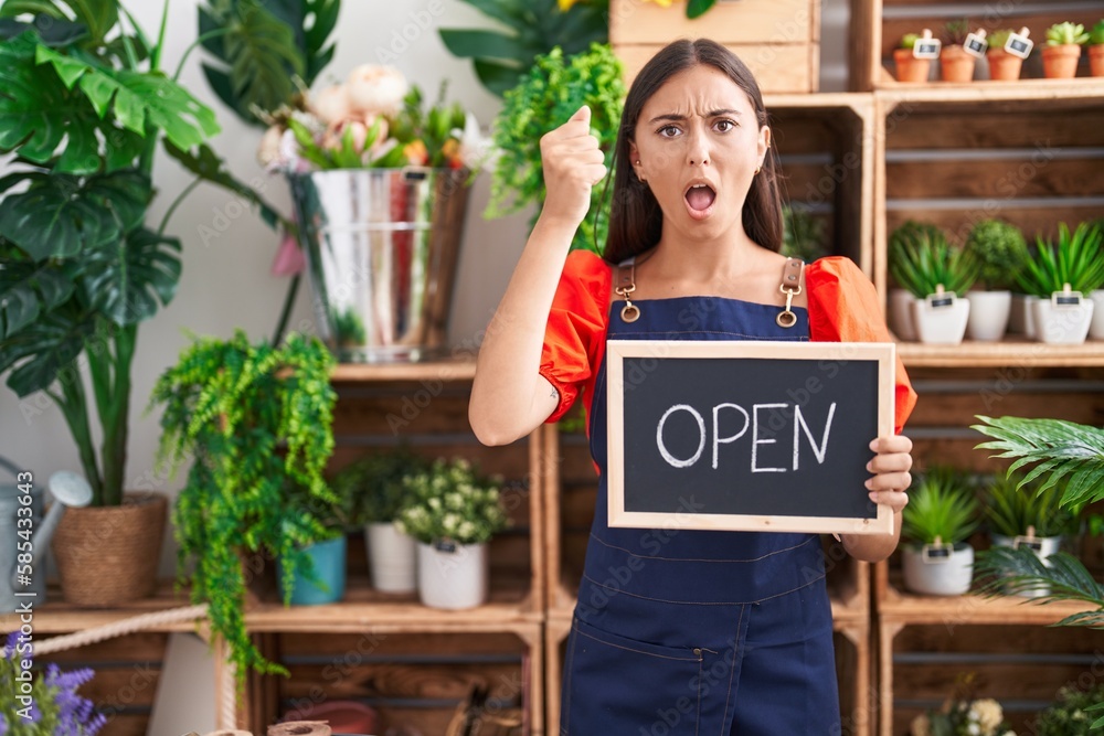 Young hispanic woman working at florist holding open sign annoyed and frustrated shouting with anger, yelling crazy with anger and hand raised Young hispanic woman working at florist holding open sign annoyed and frustrated shouting with anger, yelling crazy with anger and hand raised