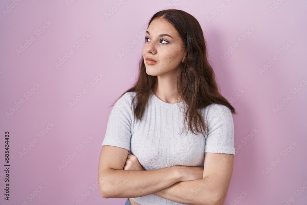 Young hispanic girl standing over pink background looking to the side with arms crossed convinced and confident Young hispanic girl standing over pink background looking to the side with arms crossed convinced and confident