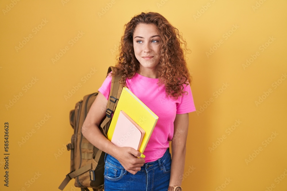 Young caucasian woman wearing student backpack and holding books smiling looking to the side and staring away thinking. Young caucasian woman wearing student backpack and holding books smiling looking to the side and staring away thinking.
