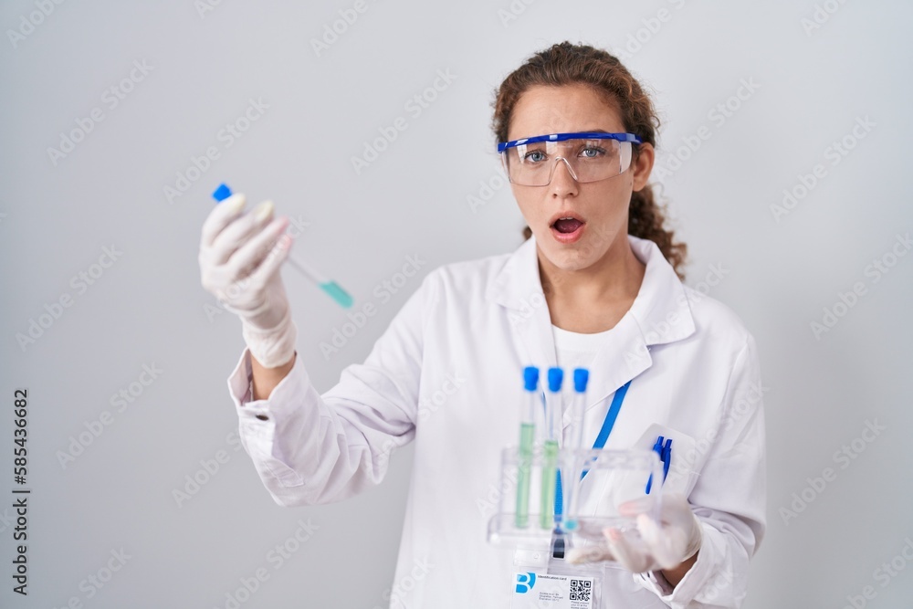 Young caucasian scientist woman working with laboratory samples afraid and shocked with surprise and amazed expression, fear and excited face. Young caucasian scientist woman working with laboratory samples afraid and shocked with surprise and amazed expression, fear and excited face.