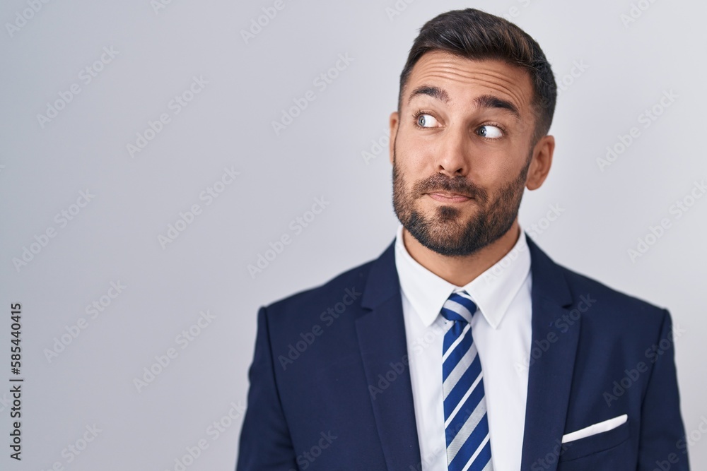 Handsome hispanic man wearing suit and tie smiling looking to the side and staring away thinking. Handsome hispanic man wearing suit and tie smiling looking to the side and staring away thinking.