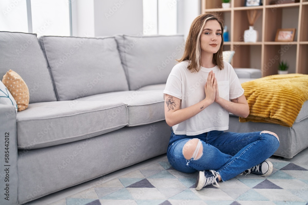 Young woman doing yoga exercise sitting on floor at home Young woman doing yoga exercise sitting on floor at home