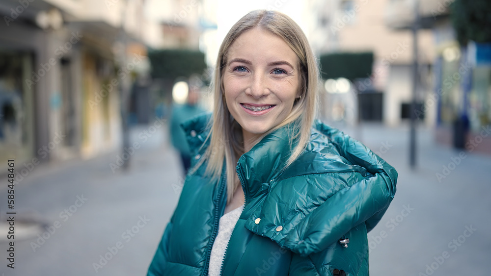 Young blonde woman smiling confident showing braces at street
