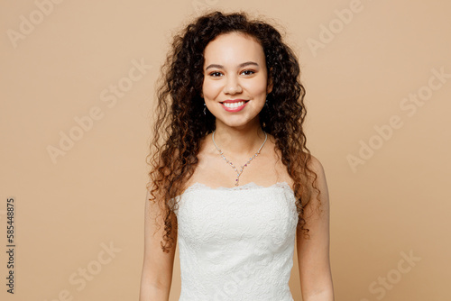 Beautiful smiilng cheerful nice happy young woman bride wear white wedding dress posing look camera isolated on plain pastel light beige background studio portrait. Ceremony celebration party concept.
