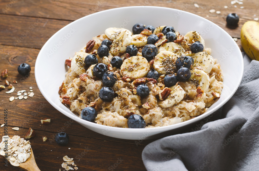 Oatmeal Bowl, Oat Porridge with Blueberry, Banana and Pecans in a Bowl on Wooden Background, Healthy Snack or Breakfast Oatmeal Bowl, Oat Porridge with Blueberry, Banana and Pecans in a Bowl on Wooden Background, Healthy Snack or Breakfast