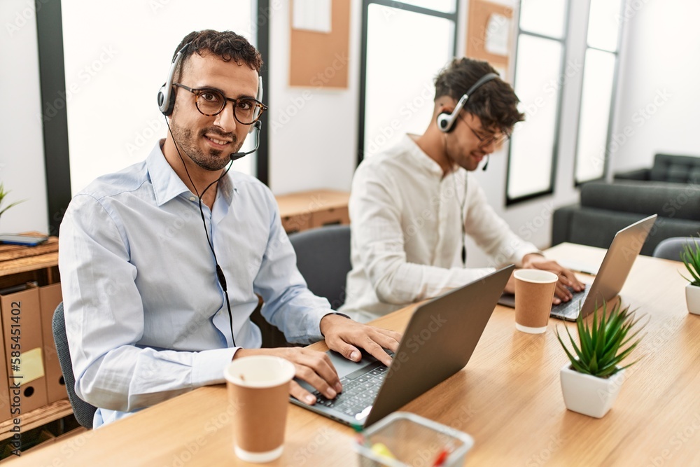 Two hispanic men call center agents smiling confident working at office Two hispanic men call center agents smiling confident working at office