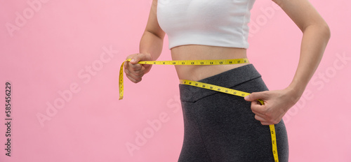 Diet and dieting. Beauty slim female body use tape measure. Woman in exercise clothes achieves weight loss goal for healthy life, crazy about thinness, thin waist, nutritionist..
