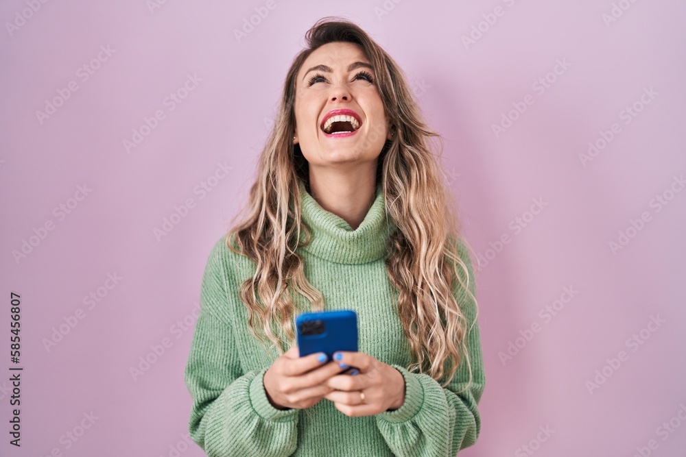 Young caucasian woman using smartphone typing message angry and mad screaming frustrated and furious, shouting with anger looking up. Young caucasian woman using smartphone typing message angry and mad screaming frustrated and furious, shouting with anger looking up.