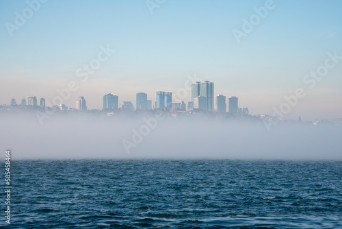 Fog over the Bosphorus Strait  the backdrop to high-rise buildings.