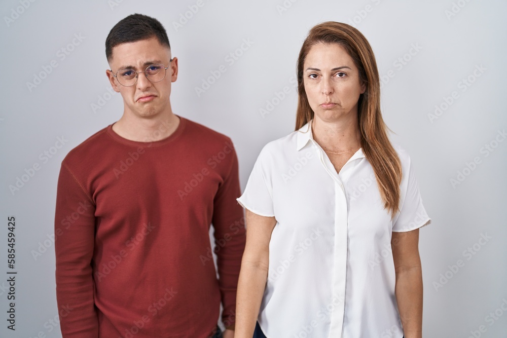 Mother and son standing together over isolated background depressed and worry for distress, crying angry and afraid. sad expression. Mother and son standing together over isolated background depressed and worry for distress, crying angry and afraid. sad expression.