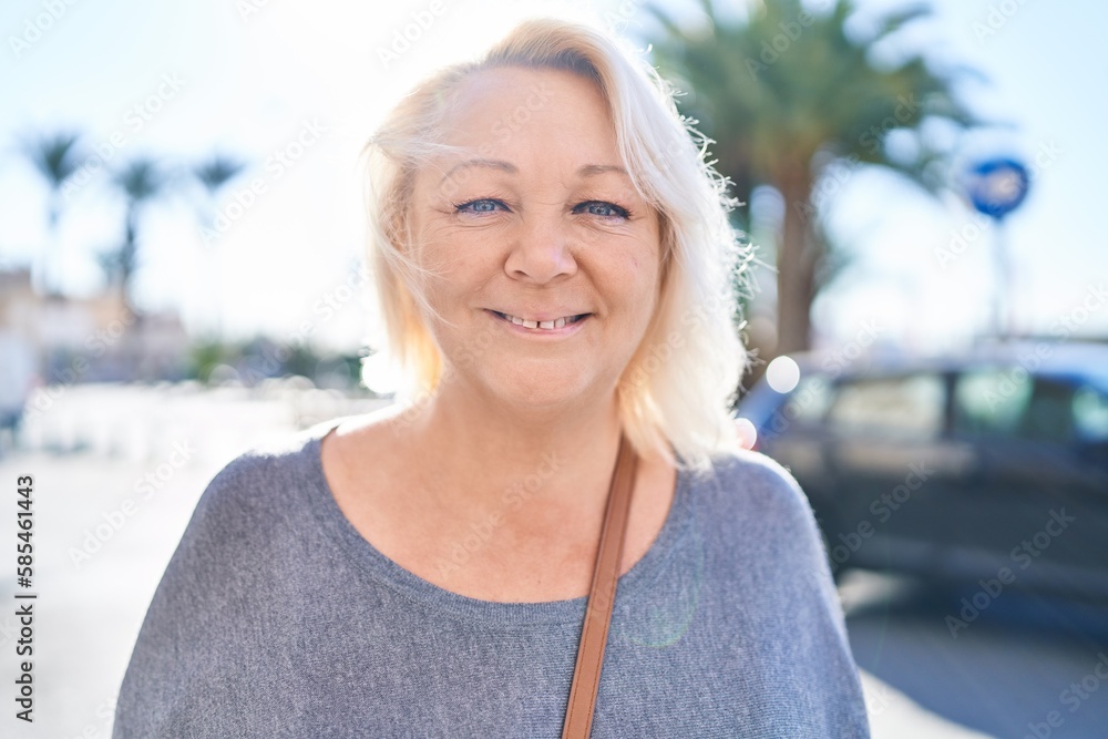 Fototapeta premium Middle age blonde woman smiling confident standing at street