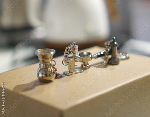 Coffee machine miniature key chain collection, in a set upp with the real coffee beans on a wooden background