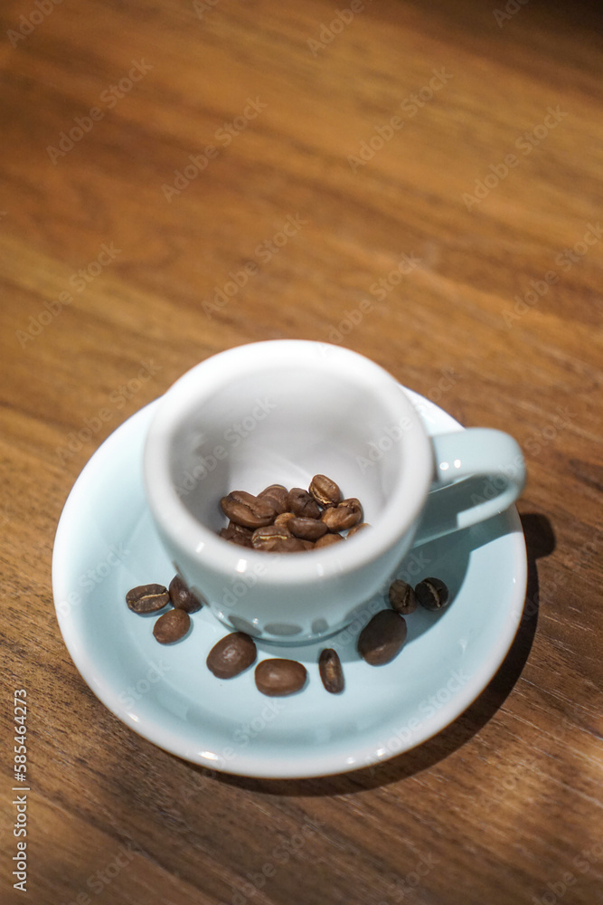 Roasted Coffee bean in an espresso coffee mug Roasted Coffee bean in an espresso coffee mug