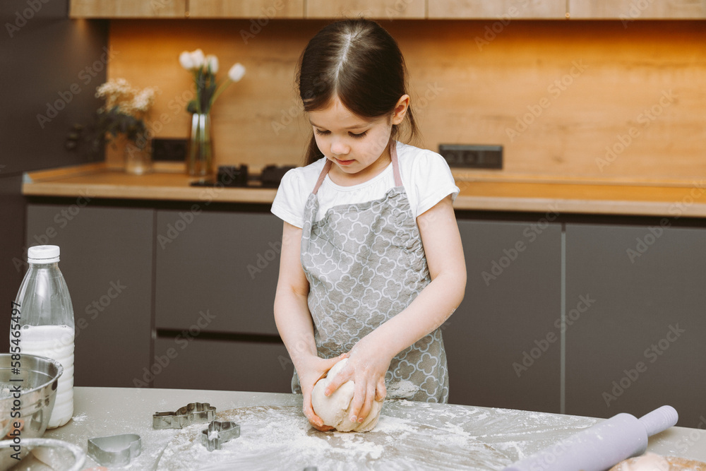 happy little girl making dough in the kitchen. a small child learns to cook food or bake yeast dough with his hands at home happy little girl making dough in the kitchen. a small child learns to cook food or bake yeast dough with his hands at home