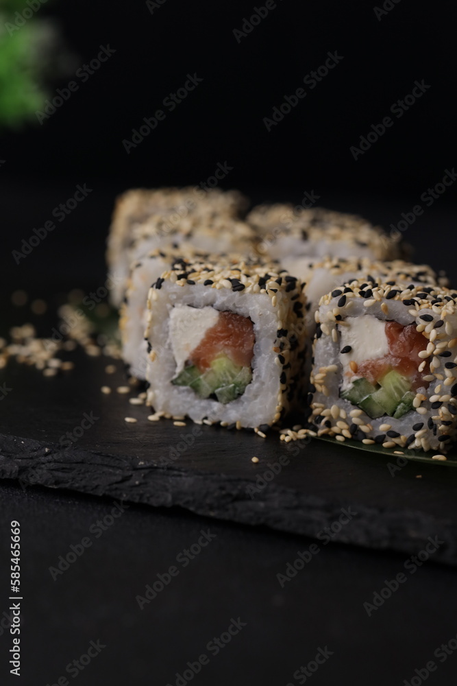 Sushi rolls on black background with salmon cheese and fish Sushi rolls on black background with salmon cheese and fish
