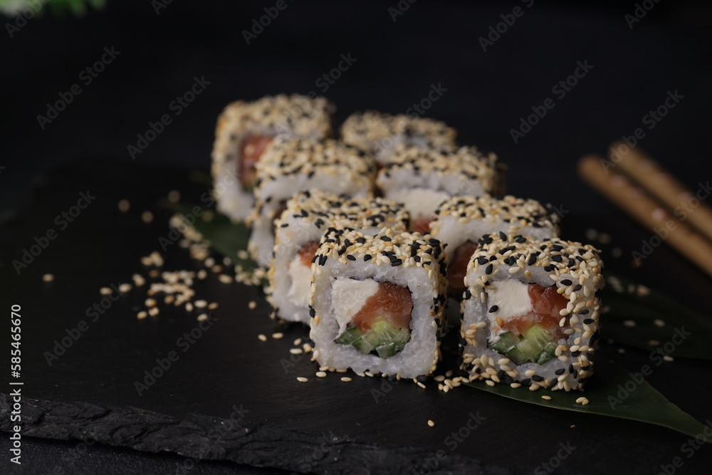 Sushi rolls on black background with salmon cheese and fish Sushi rolls on black background with salmon cheese and fish