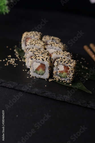 Sushi rolls on black background with salmon cheese and fish