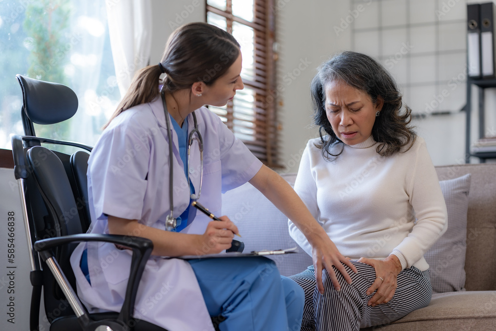 Female doctor examining the knee of an elderly Asian female patient. Female doctor examining the knee of an elderly Asian female patient.