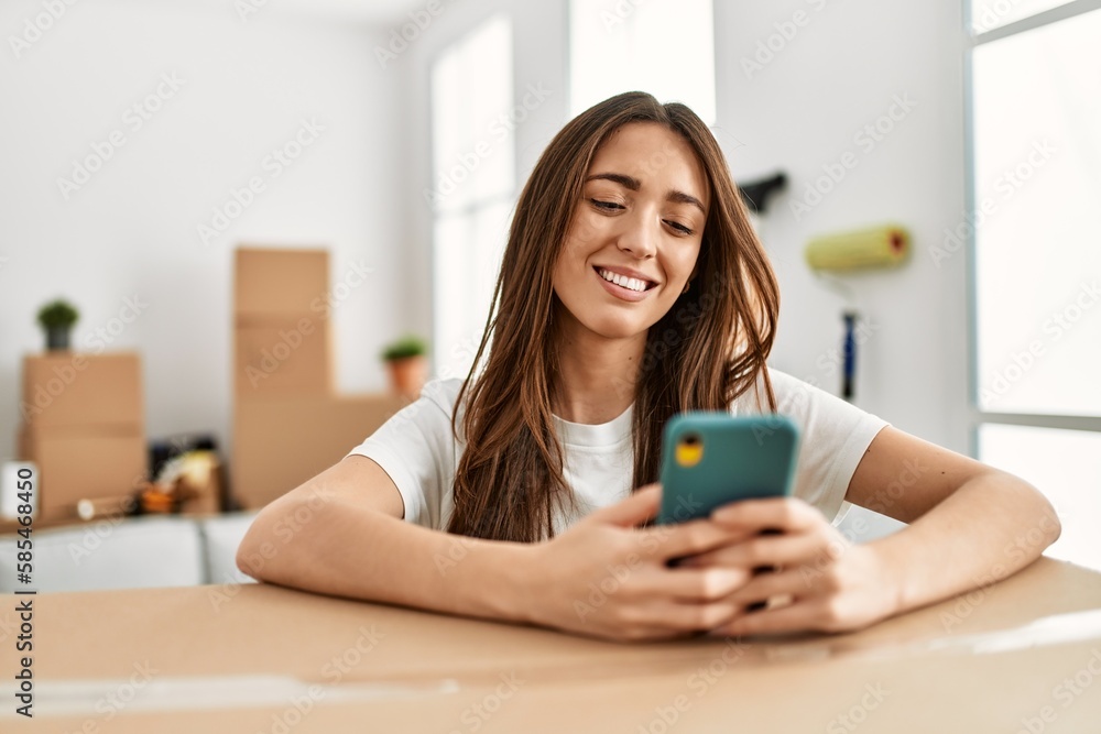 Young hispanic woman smiling confident using smartphone at new home Young hispanic woman smiling confident using smartphone at new home