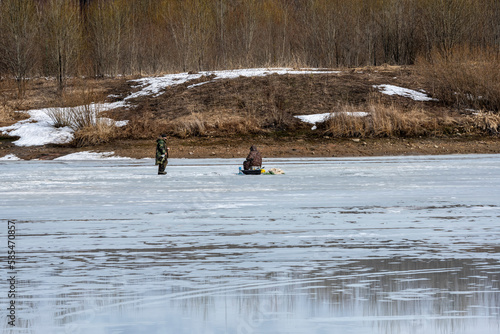 ishermen in the spring catch fish on the lake by ice fishing