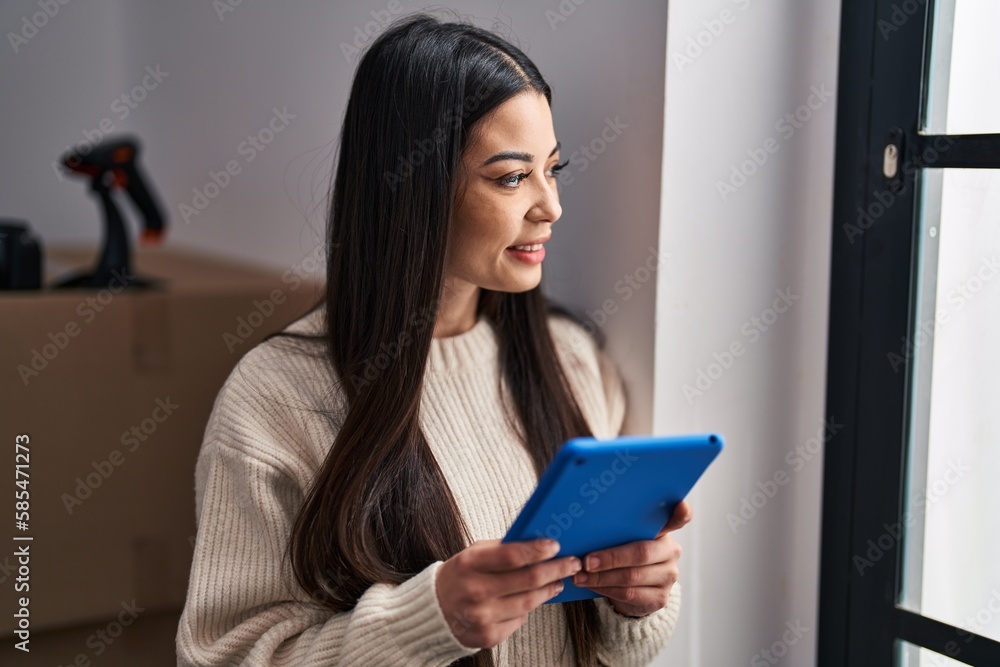 Young beautiful hispanic woman ecommerce business worker using touchpad at office Young beautiful hispanic woman ecommerce business worker using touchpad at office