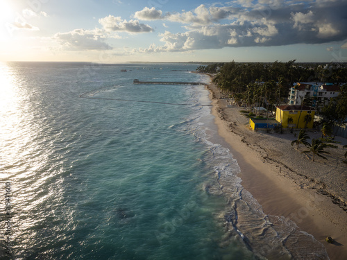 Wallpaper Mural The sea in the rays of the setting sun. city on the coast among palm trees. Beautiful seascape. There are storm clouds in the sky. Weather, nature, tourism, business. Torontodigital.ca