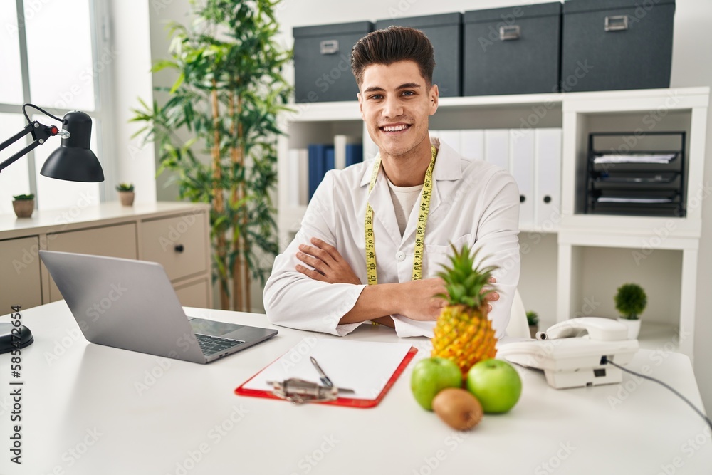 Young hispanic man wearing dietician uniform working at clinic Young hispanic man wearing dietician uniform working at clinic