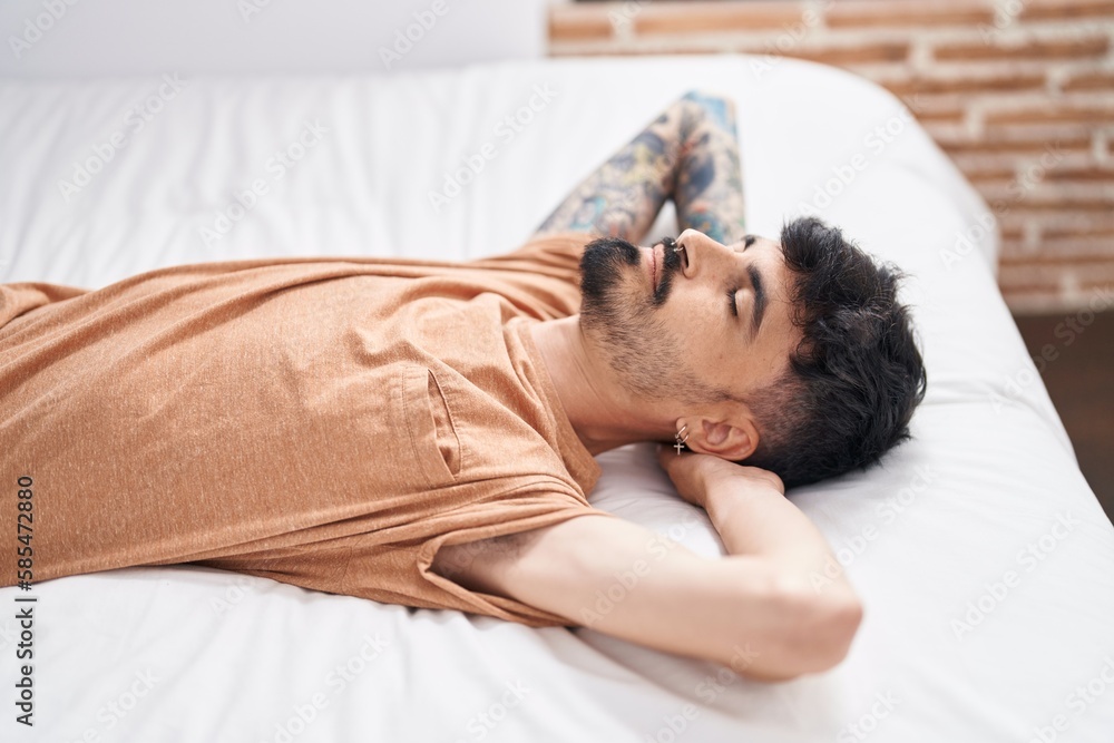 Young hispanic man lying on bed relaxed at bedroom Young hispanic man lying on bed relaxed at bedroom