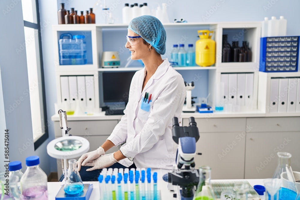 Fototapeta premium Brunette woman working at scientist laboratory looking to side, relax profile pose with natural face and confident smile.