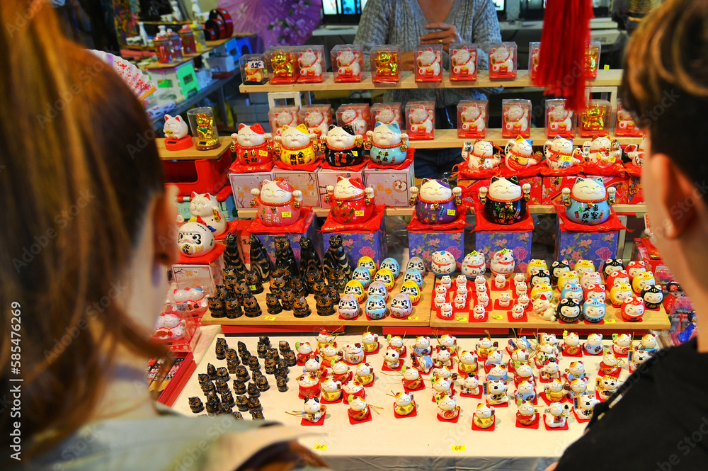 Maneki-neko figures oriental symbol of welcoming and good luck at booth market