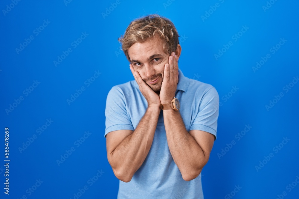 Caucasian man standing over blue background tired hands covering face, depression and sadness, upset and irritated for problem Caucasian man standing over blue background tired hands covering face, depression and sadness, upset and irritated for problem
