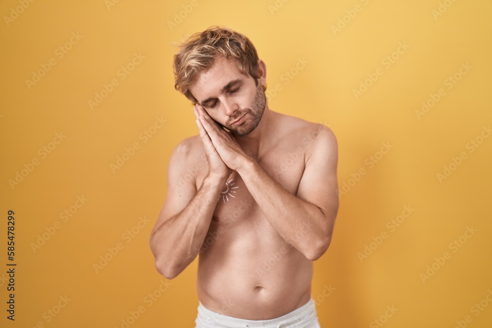 Caucasian man standing shirtless wearing sun screen sleeping tired dreaming and posing with hands together while smiling with closed eyes.