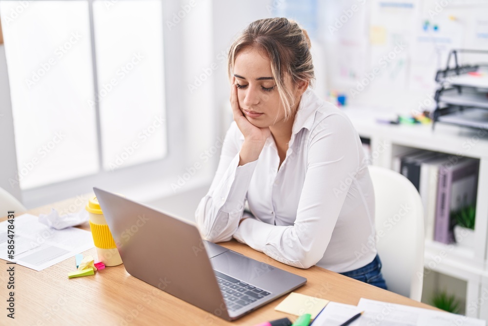 Young blonde woman business worker sitting on table with relaxed expression at office Young blonde woman business worker sitting on table with relaxed expression at office