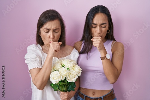 Hispanic mother and daughter holding bouquet of white flowers feeling unwell and coughing as symptom for cold or bronchitis. health care concept.