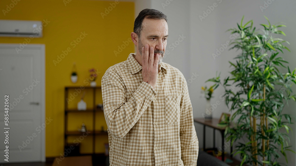 Middle age man standing with serious expression at home Middle age man standing with serious expression at home