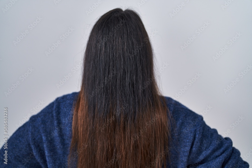 Young brunette woman standing over isolated background standing backwards looking away with arms on body Young brunette woman standing over isolated background standing backwards looking away with arms on body
