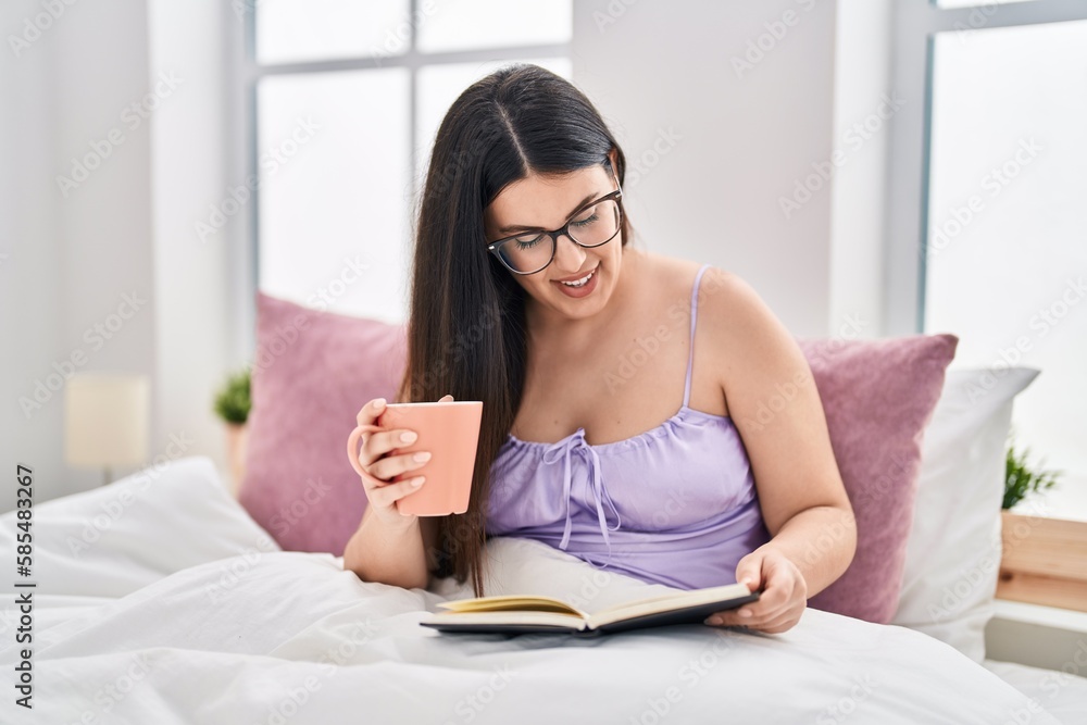 Young hispanic woman drinking cup of coffee reading book at bedroom Young hispanic woman drinking cup of coffee reading book at bedroom