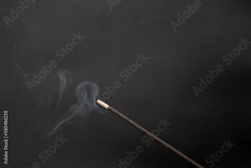 incense smoking stick on a black background