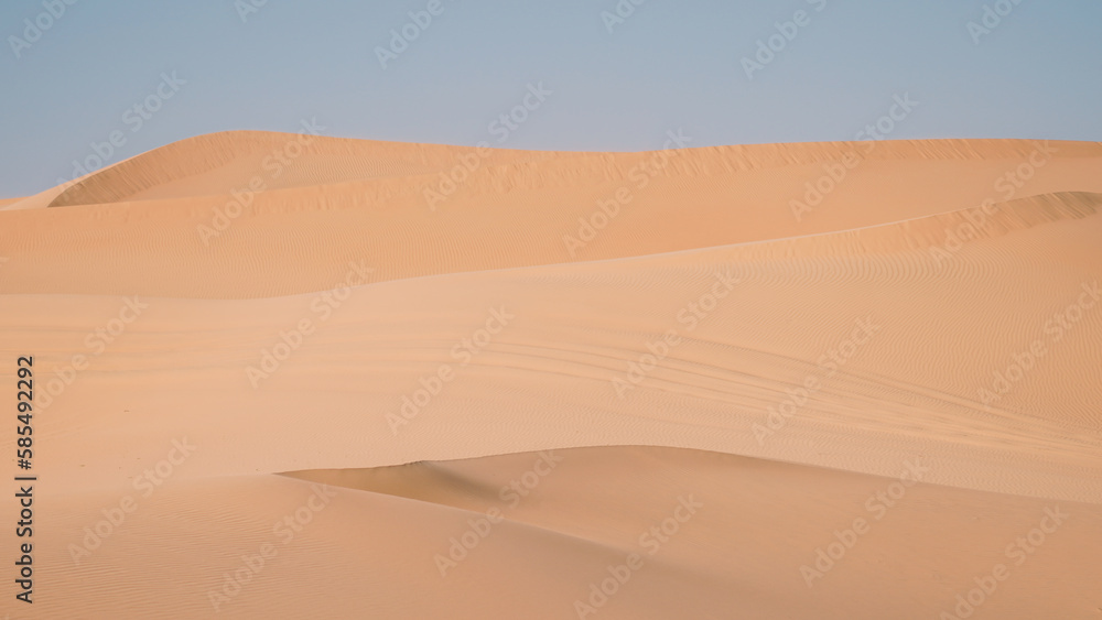 Sand dunes in the desert with a light on the top