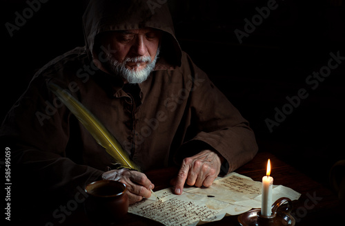 Old monk in the Middle Ages writes message