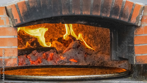 Flammes dans un four à bois avec un socca, spécialité niçoise faite avec des pois chiches et de l'huile d'olive