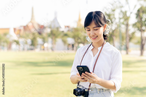 Portrait beautiful young asian woman with smartphone on summer holiday vacation trip with the grand palace in a background at Bangkok  Thailand