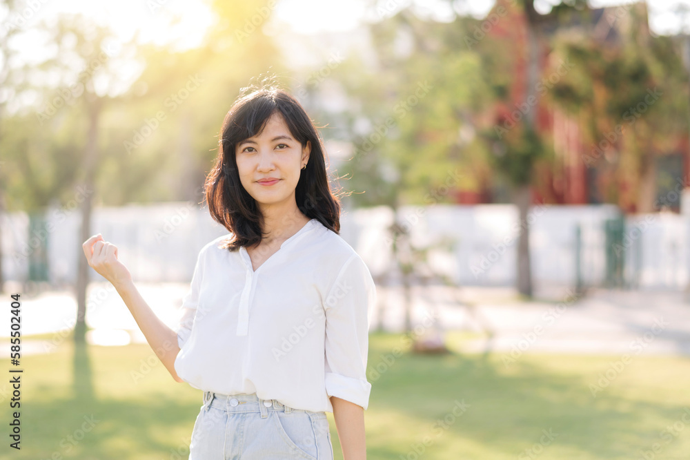Portrait young beautiful asian woman with happy smile around outdoor park in sunny summer day Portrait young beautiful asian woman with happy smile around outdoor park in sunny summer day