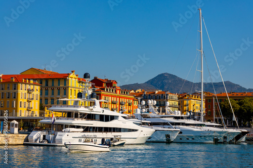 Nice port with yachts, boats and pierces in Nice Port and yacht marina district with Colline du Chateau Castle hill on French Riviera in France