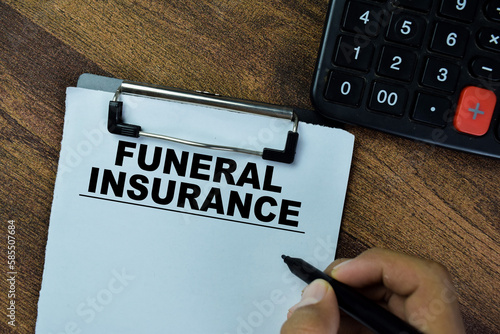 Photography Concept of Funeral Insurance write on paperwork on a book isolated on Wooden Table