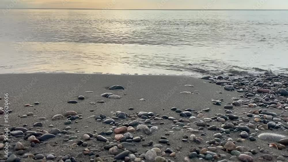 Sea waves on the beach with pebbles and stones at sunset close-up. The Black Sea coast on a summer evening. Georgia, Batumi.
Sea waves on the beach with pebbles and stones at sunset close-up. The Black Sea coast on a summer evening. Georgia, Batumi.