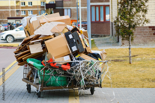 a pile of cardboard on a garbage cart. separate garbage collection. sidewalk. close-up