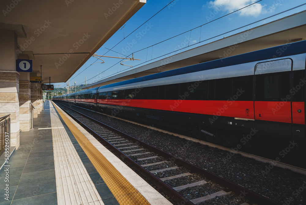 Long train arrives at rural train station in Italy. Long train arrives at rural train station in Italy.