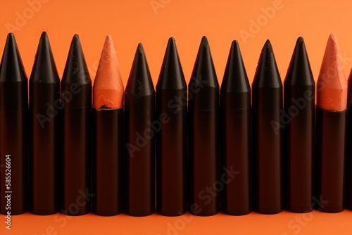  a row of black pencils lined up against an orange background with the tip of the pencil in the center of the row of the pencils. generative ai